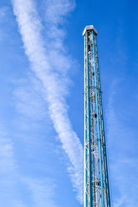 Low angle view of amusement park ride against blue sky