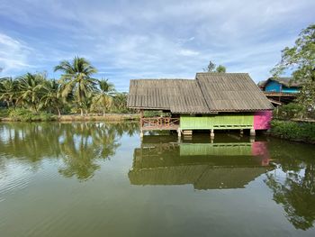 Reflection of palm trees in lake against sky