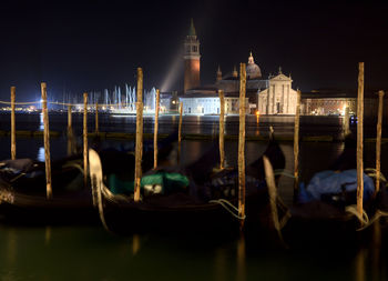 Boats moored in canal at night