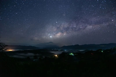 Scenic view of illuminated mountains against sky at night