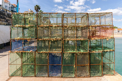 Stack of fishing net on sea against sky