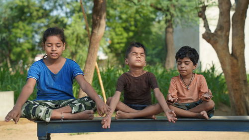 Kids in meditate pose together in nature a field garden park, family kid sport and 