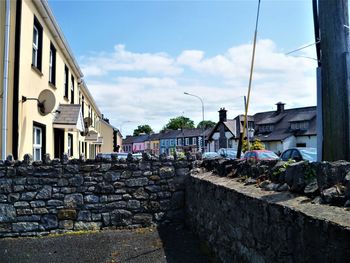 Street by buildings against sky