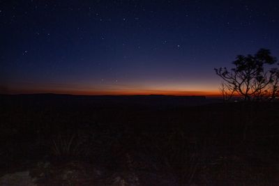 Scenic view of silhouette field against sky at night