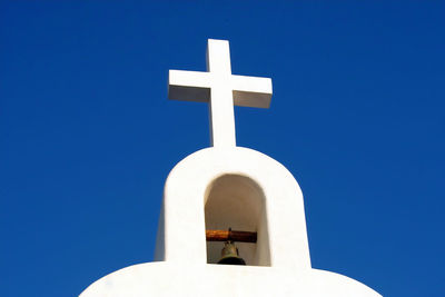 Low angle view of cross against clear blue sky