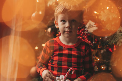 Happy little boy dreamer waiting at miracle santa enjoy sweets color lollipop. 
