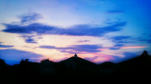 Silhouette of buildings against sky at dusk