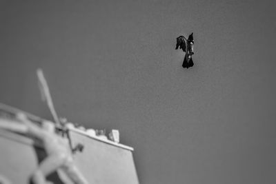 Low angle view of man jumping against clear sky