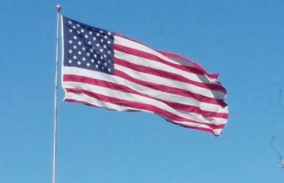 Low angle view of flag against clear sky