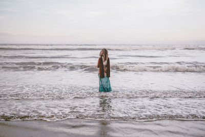 Rear view of woman standing on beach