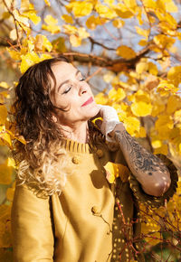 Mature woman standing by autumn tree