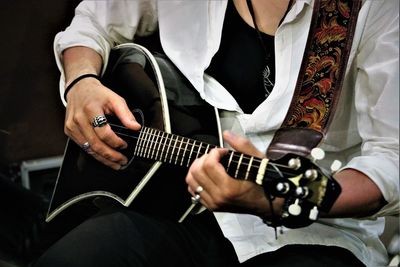 Midsection of man playing mandolin