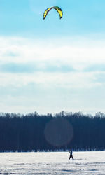 Person paragliding against sky during winter