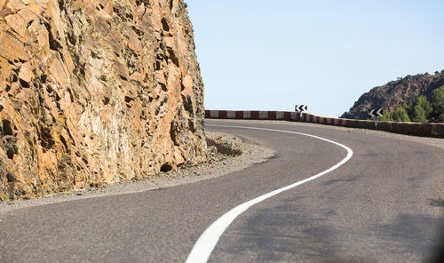 Road by mountain against clear sky