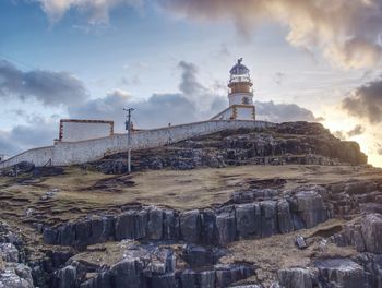 Lighthouse with tower against to evening sky. popular neist point, spit of land isle of skye, uk