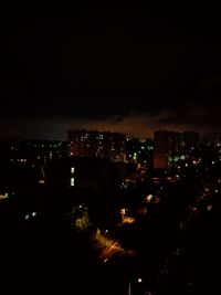 Illuminated cityscape against sky at night