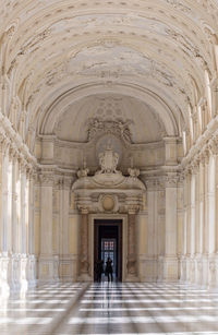 Woman walking in corridor of historical building