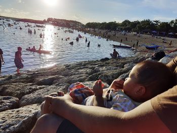 People at beach against sky