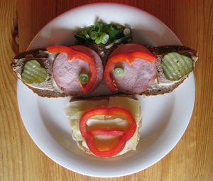 High angle view of anthropomorphic face made from bread and vegetables