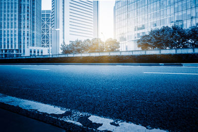 City street by modern buildings against sky