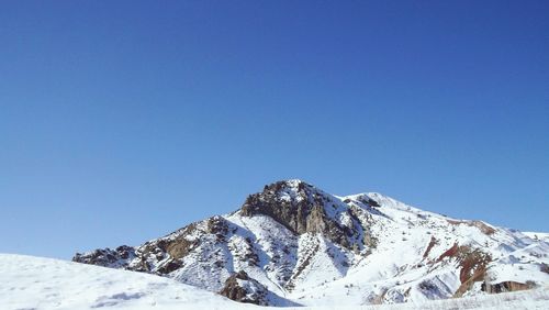 Scenic view of snowcapped mountains against clear blue sky