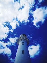 Low angle view of lighthouse by building against sky