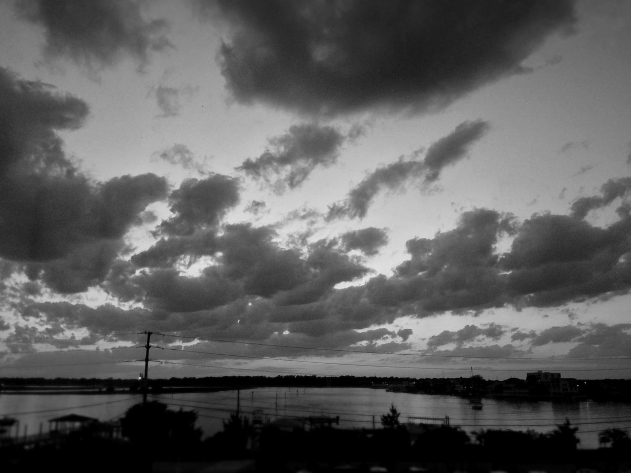 sky, cloud - sky, water, silhouette, cloudy, sunset, scenics, cloud, tranquility, river, dusk, tranquil scene, nature, beauty in nature, weather, sea, built structure, connection, overcast, outdoors