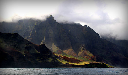 Scenic view of sea and mountains against sky