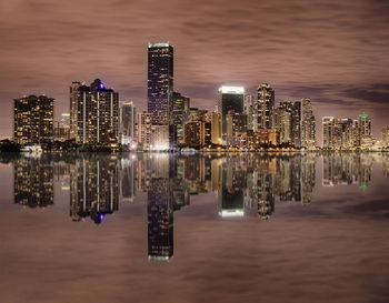 Reflection of illuminated buildings in city at night