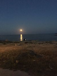 Scenic view of sea against clear sky at night