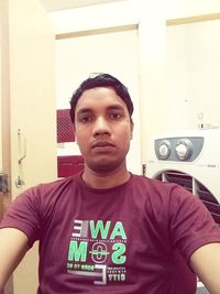 Portrait of young man standing at home
