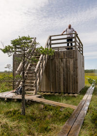 The summer swamp. a man in a white shirt at the lookout tower. bog background and vegetation