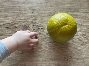 High angle view of hand holding fruit on table