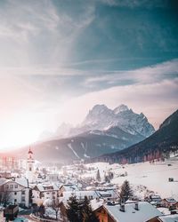 Townscape and mountains against sky during winter