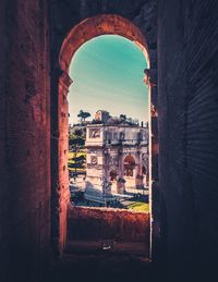 Buildings against clear sky seen through arch window