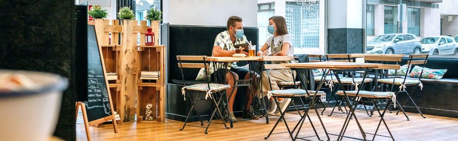 Couple wearing mask sitting in restaurant