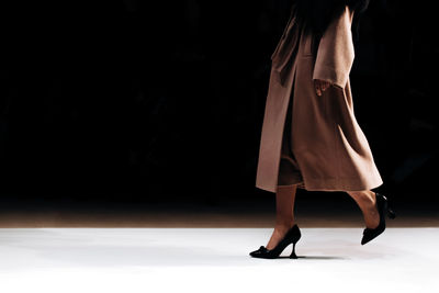 Classy fashion details of long brown autumnal coat and high heels shoes, women's fashion cloth