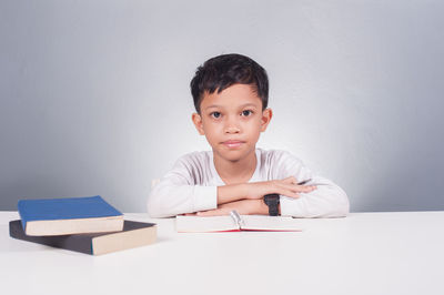 Portrait of boy sitting on table