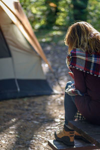 Rear view of woman sitting on picnic table