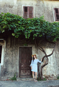 Full length of girl standing against house