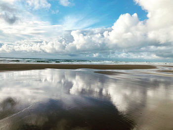 Beach reflecting clouds and sky