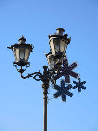 Low angle view of christmas decoration against blue sky