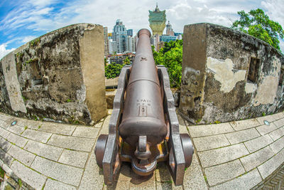 Bicycles on the wall of fort against sky