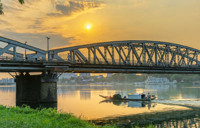 Bridge over river against sky during sunset