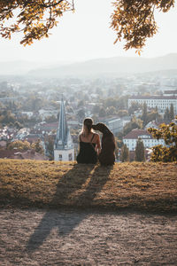 Woman looking at city buildings against sky