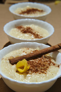 Three rice pudding desserts on a brown base decorated with cinnamon a