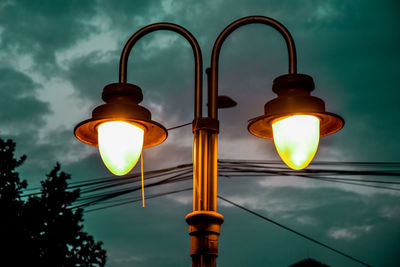 Low angle view of illuminated street light against sky