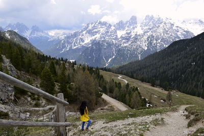 Rear view of person on snowcapped mountains against sky