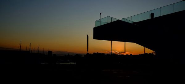 Silhouette bridge against clear sky during sunset