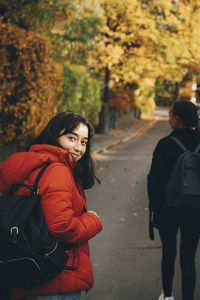 Portrait of teenage girl walking on road during autumn